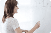 女性がホワイトボードに書いている写真